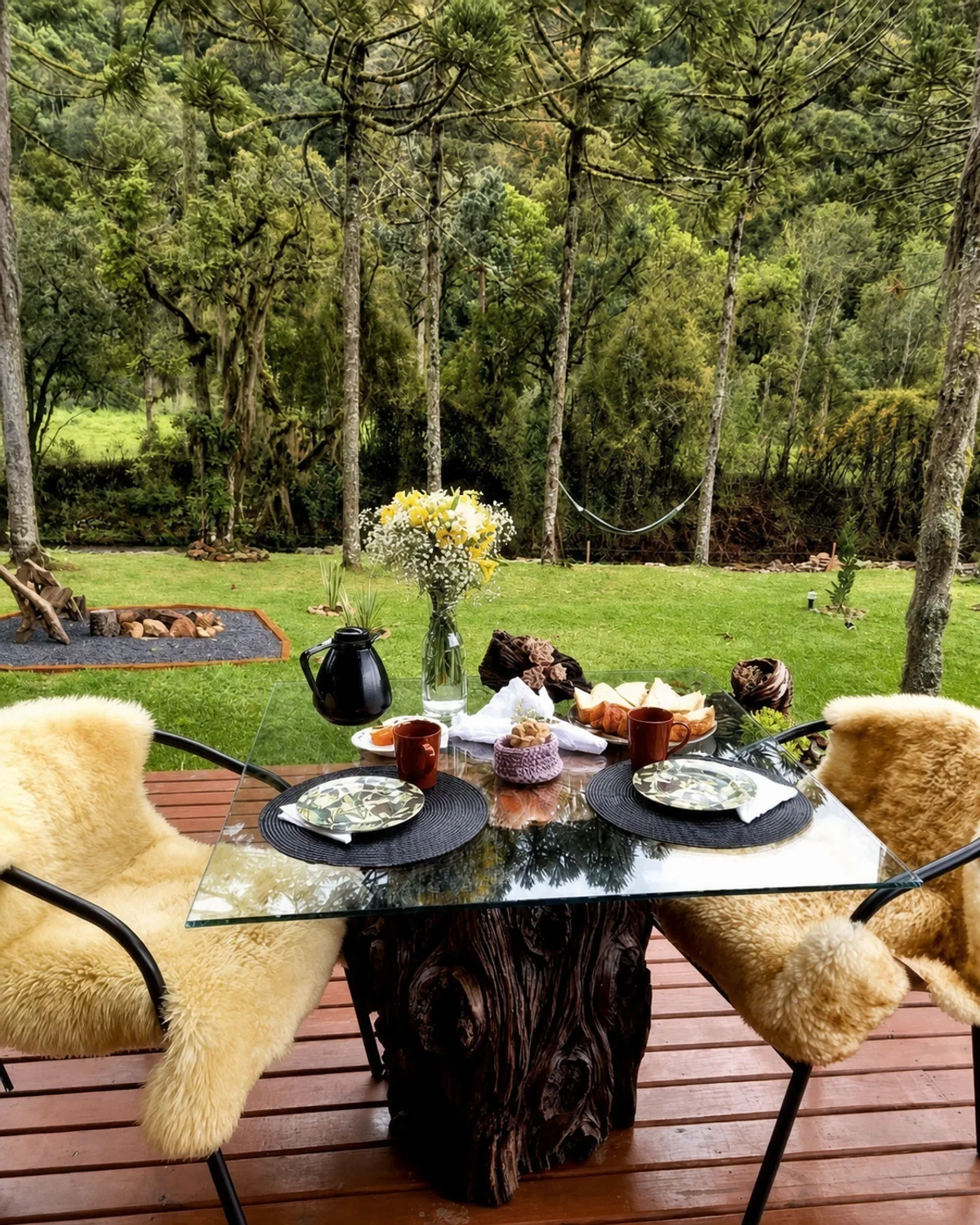 Mesa de café da manhã no deck da Cabana Araucária diante do jardim