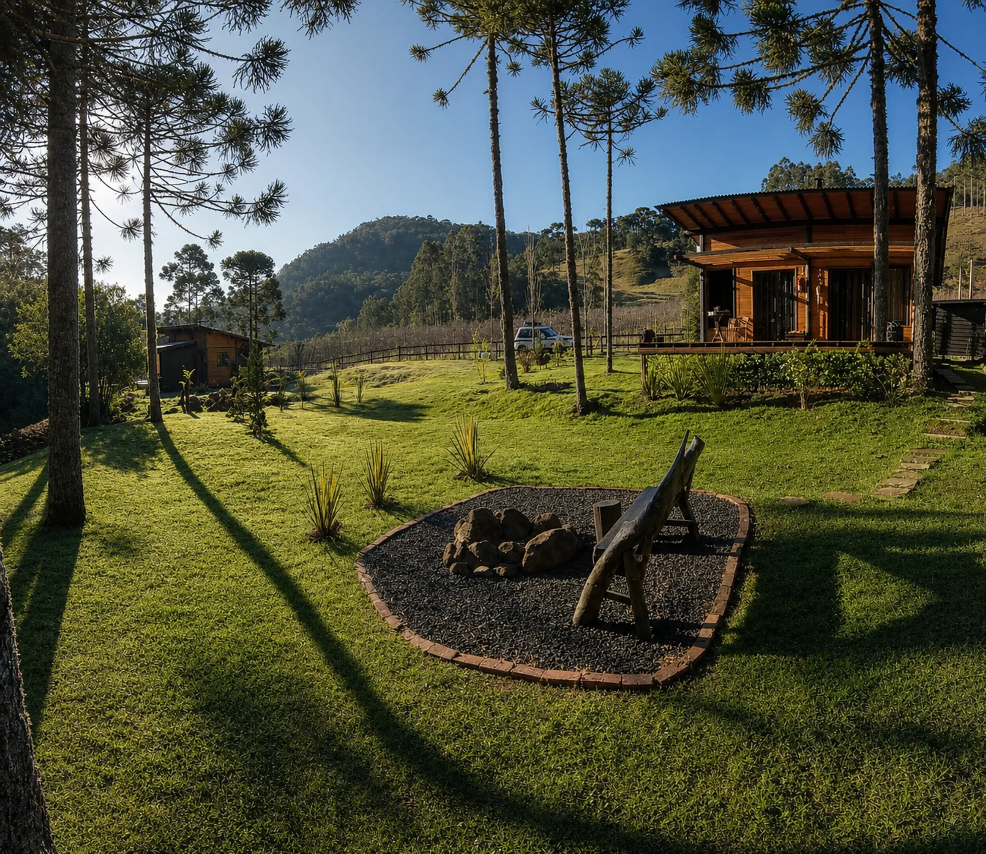 Cabana Araucária em um terreno gramado cercado pela serra